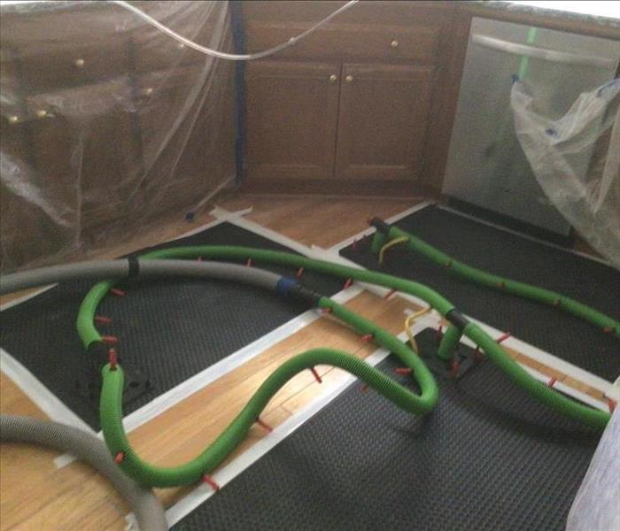 Servpro Injectidry drying system drying out hardwood floors in a home.